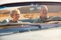Senior couple on a US road trip, seen through car windscreen Royalty Free Stock Photo