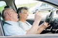 Senior couple using cellular while driving Royalty Free Stock Photo