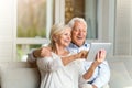 Senior couple using digital tablet at home Royalty Free Stock Photo