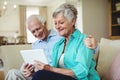 Senior couple using digital tablet in living room Royalty Free Stock Photo