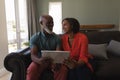 Senior couple using digital tablet in living room at home Royalty Free Stock Photo