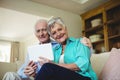 Senior couple using digital tablet in living room Royalty Free Stock Photo