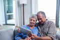 Senior couple using a digital tablet on sofa Royalty Free Stock Photo