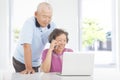 Senior couple using a laptop and a cell phone Royalty Free Stock Photo