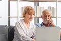 Senior couple using laptop checking their bills, retired elderly family reading documents Royalty Free Stock Photo