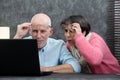 Senior couple using laptop, they having difficulties and vision problems