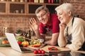 Senior couple using laptop in kitchen, making video call Royalty Free Stock Photo