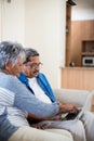 Senior couple using laptop in living room Royalty Free Stock Photo