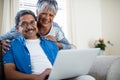 Senior couple using laptop in living room at home Royalty Free Stock Photo