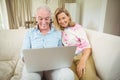 Senior couple using laptop in living room Royalty Free Stock Photo