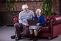 Senior couple using laptop while sitting on couch Royalty Free Stock Photo