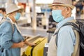 Senior couple using a self-service luggage drop-off unit