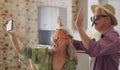 Senior couple, video call and wave in home, silly and costume for joke on phone in retirement. Elderly people, greeting Royalty Free Stock Photo