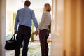 Senior couple walk in to hotel room holding hands, back view Royalty Free Stock Photo