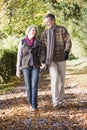 Senior couple walking along autumn path Royalty Free Stock Photo