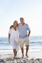 Senior Couple Walking Along Beach Royalty Free Stock Photo