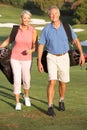 Senior Couple Walking Along Golf Course Royalty Free Stock Photo