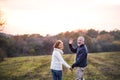 Senior couple walking in an autumn nature, holding hands. Royalty Free Stock Photo