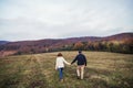 Senior couple walking in an autumn nature, holding hands.