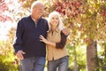 Senior Couple Walking Through Autumn Woodland Royalty Free Stock Photo