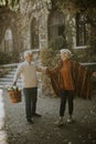 Senior couple walking with basket full of flowers and groceries in autumn park Royalty Free Stock Photo