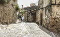 Senior couple walking in a medieval street in Trujillo, Spain