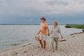 Senior couple walking with picnic basket near the river. Royalty Free Stock Photo