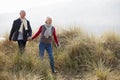 Senior Couple Walking Through Sand Dunes On Winter Beach Royalty Free Stock Photo