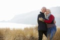 Senior Couple Walking Through Sand Dunes On Winter Beach Royalty Free Stock Photo