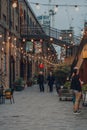 Senior couple walking under the lights in Coal Drops Yard, London, UK