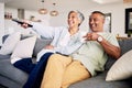 Senior couple, watching tv and relax on sofa in home living room, laughing and together for funny comedy show. Elderly Royalty Free Stock Photo