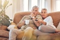 Senior couple, watching tv and sofa in relax for streaming, movie or series in living room at home. Elderly man and