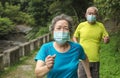 Senior couple wearing face mask and walking trough nature park Royalty Free Stock Photo