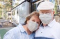 Senior Couple Wearing Medical Face Masks In Front of Their Beautiful RV At The Campground