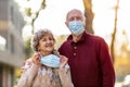 Senior couple wearing protective face masks outdoors