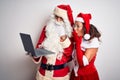 Senior couple wearing Santa Claus costume using laptop over isolated white background cover mouth with hand shocked with shame for Royalty Free Stock Photo