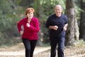 Senior couple wearing sportswear and running in forest Royalty Free Stock Photo