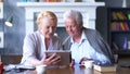 Senior couple websurfing on internet with digital tablet. Royalty Free Stock Photo