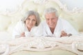 Senior couple in white bathrobes drinking tea in bed Royalty Free Stock Photo