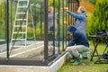 Senior couple working on a project in their garden. Man and woman constructing a greenhouse in their backyard Royalty Free Stock Photo