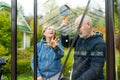 Senior couple working on a project in their garden. Man and woman constructing a greenhouse in their backyard Royalty Free Stock Photo