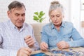 Senior couple working on a puzzle at home Royalty Free Stock Photo