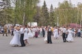 Senior couples dance in park.