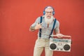 Senior crazy man with boombox stereo playing rock music - Trendy mature guy having fun dancing with vintage radio - Joyful elderly
