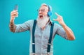 Senior crazy man using smartphone app for creating playlist with rock music - Trendy tattoo guy having fun with mobile phone