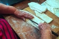 A senior cutting flat pasta dough into strips