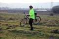 A senior cyclist wearing his bicycle cross the abandoned field