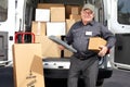 Senior delivery man with parcel near truck. Royalty Free Stock Photo