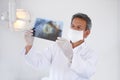 Senior dentist, man and xray of teeth for dental surgery, healthcare and oral health with face mask in clinic. Medical