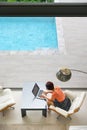 Senior digital nomad woman working at luxury villa in Phuket. andaman sea as background